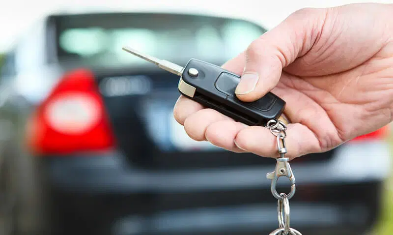 car key being held by a locksmith working on the car