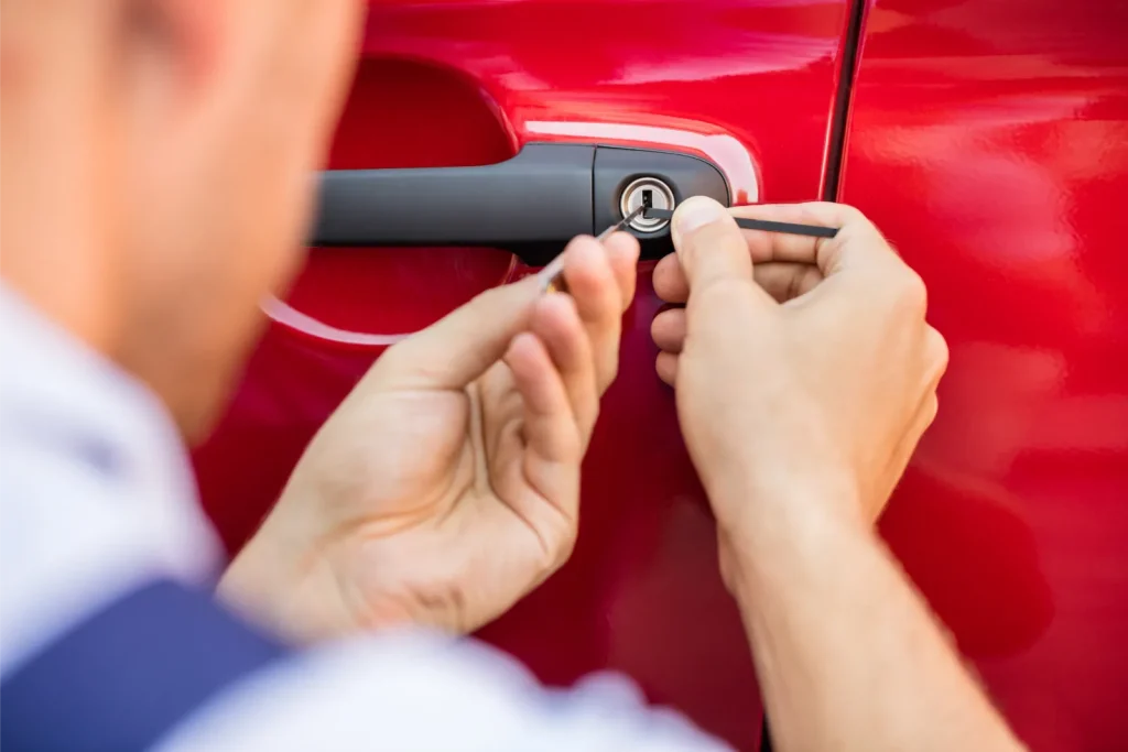 man working on locked out red car with expert tools